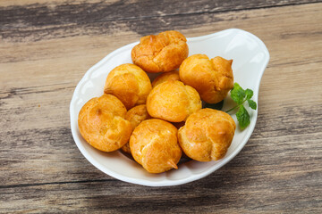 Sweet tasty profiteroles heap in the bowl