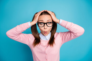 Portrait of astonished school girl impressed academic exam schedule touch face hands wear pastel sweater isolated over blue color background