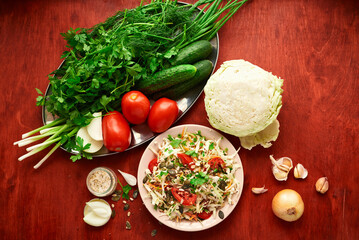 healthy food - fresh chopped vegetables on a wooden background, tomatoes and greens