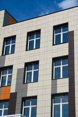 facade of a modern building on a bright Sunny day, siding and Windows, beautiful exterior of the new building