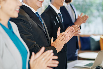 Business people standing at clapping to coworker after his inspiring speech