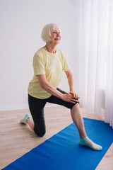senior woman doing yoga indoor. Anti age, sport, yoga concept