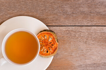 Bael fruit juice or quince tea and dried bael sliced fruit (Aegle marmelos or wood golden apple) isolated on old rustic wooden table background. healthy drinks concept.Top view.Flat lay.Vintage styles