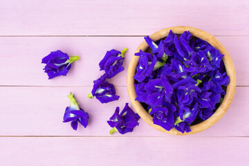 Butterfly pea or blue pea , bluebellvine, cordofan pea ( clitoria ternatea ) with green leaf isolated on wood table background. Top view. Flat lay.