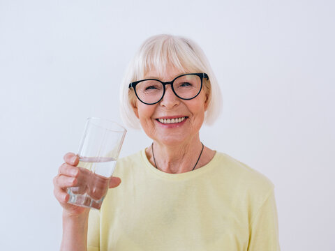 Senior Woman Holding Glass Of Water And Drinking Water. Healthy Lifestyle, Sport, Anti Age Concept