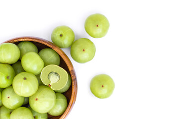 Close up  Indian gooseberry fruits ( Amla, phyllanthus emblica ) and cut i n half slice in wooden bowl isolated on white background. Top view. Flat lay.