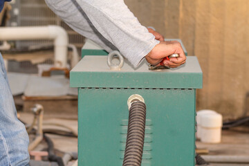 a professional electrician is fixing electric heavy industry equipment  