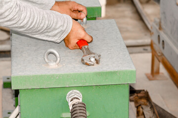 a professional electrician is fixing electric heavy industry equipment  
