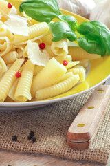 assiette de pâtes accompagnée de parmesan sur une table en bois