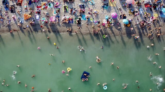 overcrowded beach vacation top view. Having fun on beach summer vibes. Original aerial drone artistic creative composition from above unusual perspective. Odessa Ukraine Black sea resort Video footage