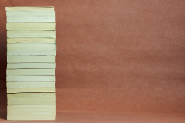 a stack of thick vintage books on a brown background
