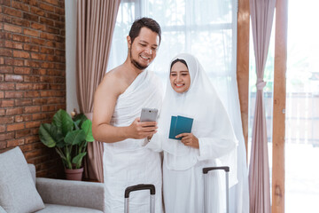Obraz premium portrait of muslim couple making a phone call while umrah and hajj