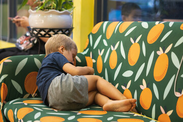 Little sad abused blond boy cowers away from camera. Family relationship, childhood problems and...