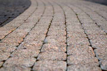 Texture of gray and yellow patterned paving tiles on the ground of street, perspective view. Cement brick squared stone floor back. Design, background. Blurred image, selective focus.