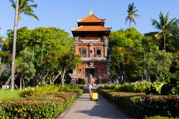 Tourist girl with a yellow suitcase