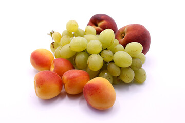 Grape bunch, peaches and ripe apricot close-up on a white background
