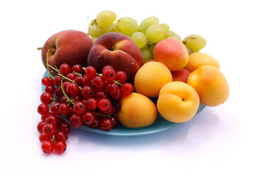 Grape bunch, peaches, red currants and apricot close-up on a white background