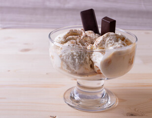 delicious creamy milky vanilla ice cream with caramel and chocolate addings in a glass container 