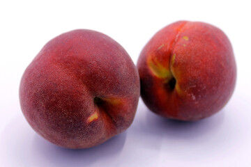 Two ripe red peaches closeup isolated on white background