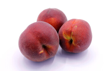 Three ripe red peaches close-up isolated on a white background