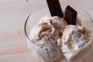 delicious creamy milky vanilla ice cream with caramel and chocolate addings in a glass container 