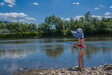 Cute little child girl fishing on the river