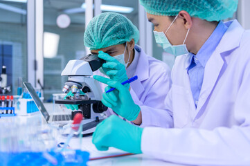 Scientist team researching Coronavirus cure in the laboratory. Asian Doctor working on vaccine...