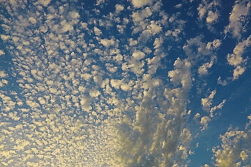 nubes blancas en cielo azul iluminadas por el sol del atardecer