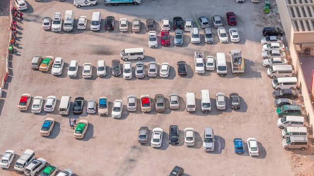 Aerial view full cars at large outdoor parking lots timelapse in Dubai, UAE. Office and recidential parking congestion and crowded parking lot with other cars try getting in and out, finding parking