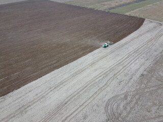 Tractor plows a field, aerial view. Agricultural landscape.