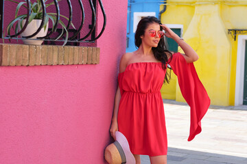 elegant, fashionable girl with glasse stay in the street , in a romantic Burano,Italy