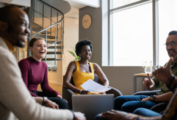 Diverse businesspeople laughing during an office meeting together