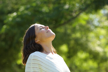Middle age woman breathing fresh air in the park