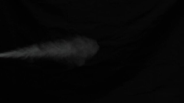Close up scene on industry white color spray spraying isolated on black background, smoke spout when smoker smoking, toxic fume on exhaust pipe, perfume stream on light in dark, exhale gas in cold air