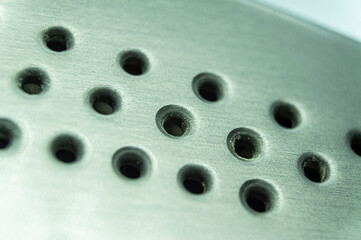 Round holes in metal close-up.
