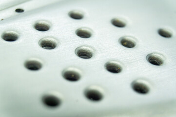 Round holes in metal close-up.