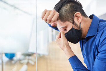 Business Mann mit Maske leidet an Überlastung