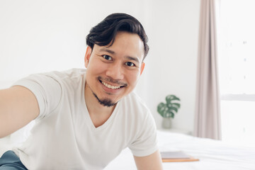 Fototapeta na wymiar Innocences smile of happy Asian man take selfie photo of himself.