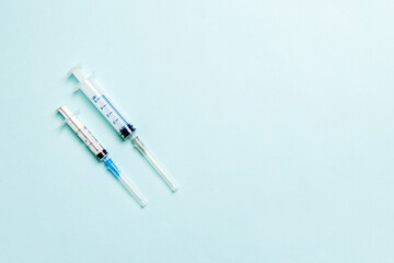 Top view of syringes in a row for medical injection on colorful background with copy space. Health and vaccination concept