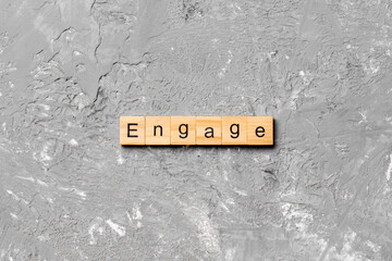 ENGAGE word written on wood block. ENGAGE text on cement table for your desing, concept