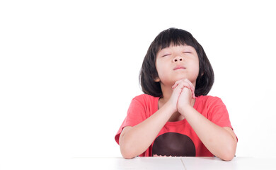 kid is praying on white background, hands folded in prayer
