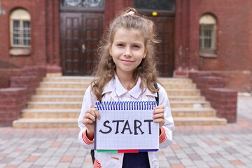 Elementary school girl student with notepad and handwritten word start