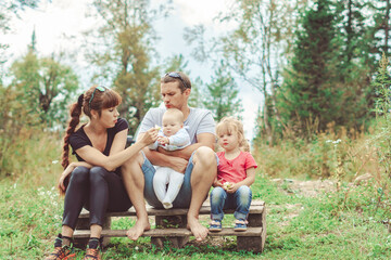 Fototapeta premium family with children sitting on the river Bank