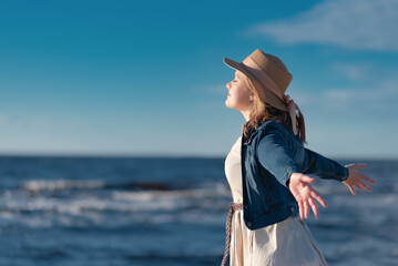 The concept of peace of mind and happiness. A woman with blond hair in a straw hat, a beige dress...