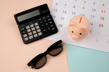 Piggy bank with a monthly calendar, calculator. Payment of rental housing or loans.