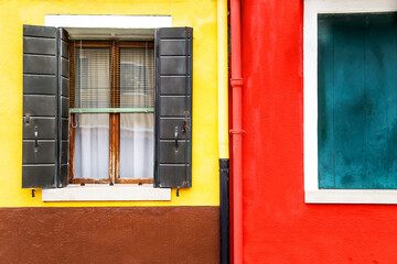 Obraz na płótnie Canvas Window with shutters open on a yellow and red wall background. Copy space.