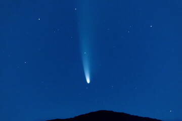 Naklejka na ściany i meble Comet falling in a night sky over a mountain