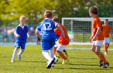 Obraz premium Football Match For Children. Training and Football Soccer School Tournament. Group of Boys Playing Football