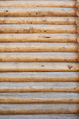 A wall made of natural wood of different sizes and shapes, Log house or barn, textured horizontal walls