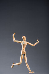 wooden marionette in tie on black background